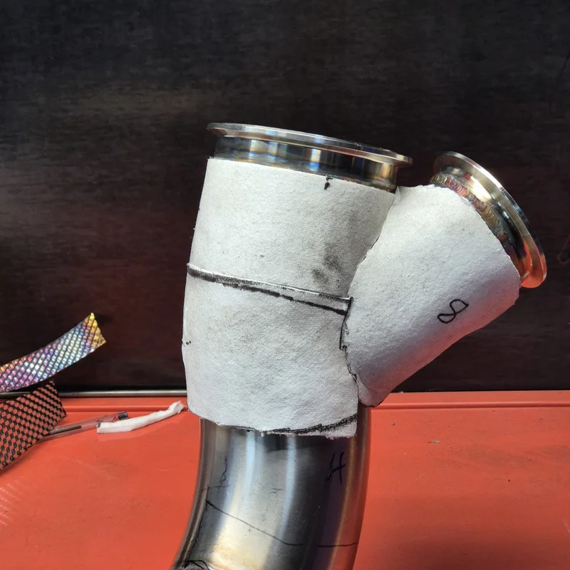 Three sections of ceramic paper attached to the exhaust via adhesive to hold them in place during install. The adhesive will burn off during normal running.