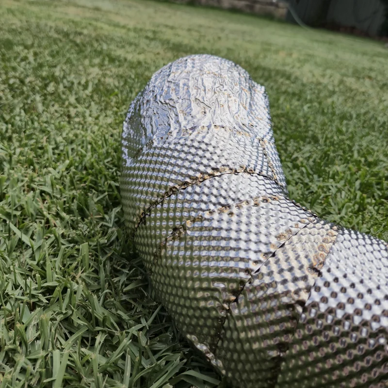 Close-up of the spot-weld pattern on an embossed stainless steel exhaust heat shield.